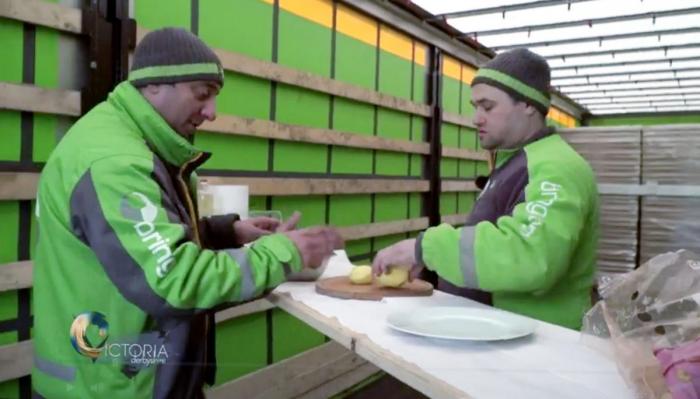 Her lager rumenske Bring-sjåfører middag i den tomme lastebilhengeren, mens de venter på flere kabotasjeoppdrag. Foto: Skjermdump / BBC