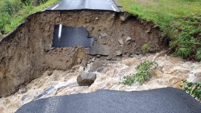 DELT I TO: På Austsidevegen i Begnadalen hadde vannmassene gått rett over fylkesvei 2458 Nordre Grimsrud. Foto: Privat