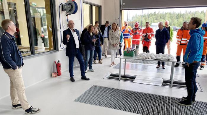 KLAR TALE TIL SAMFERDSELSMINISTEREN: Guttorm Tysnes (til venstre) talte til samferdselsministeren (til høyre) og resten av forsamlingen på nye Ånestad trafikkstasjon. Han var ikke redd for å framføre Innlandets ønske til samferdselsministeren: Få bygget de siste ni kilometerne med veg mellom Løten og Hamar også. Foto: Erik Rebne Larsstuen, Statens vegvesen